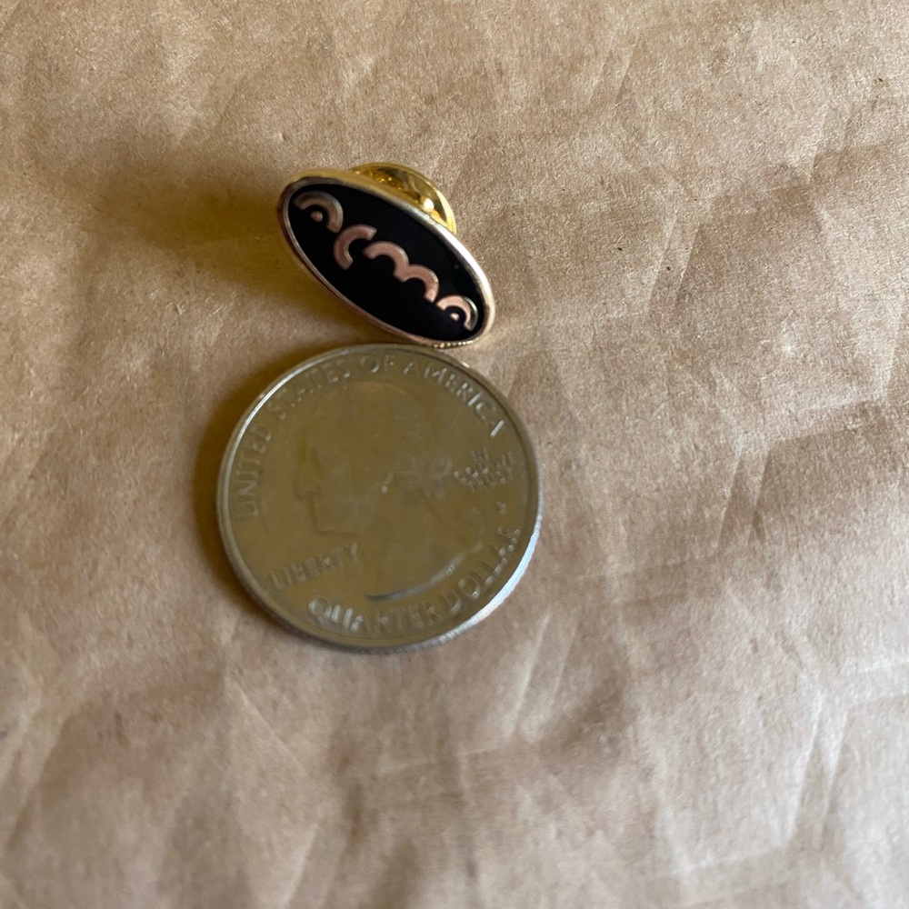 Stylized “Acme” Black Oval Enamel Lapel Pin